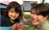 A young child and an educator explore the playground in an early childhood centre